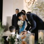 Chú rể cúi xuống trò chuyện cùng bé Ring Bearer trong lễ cưới.