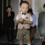 Bé Ring Bearer trong trang phục sáng màu tại lễ cưới.